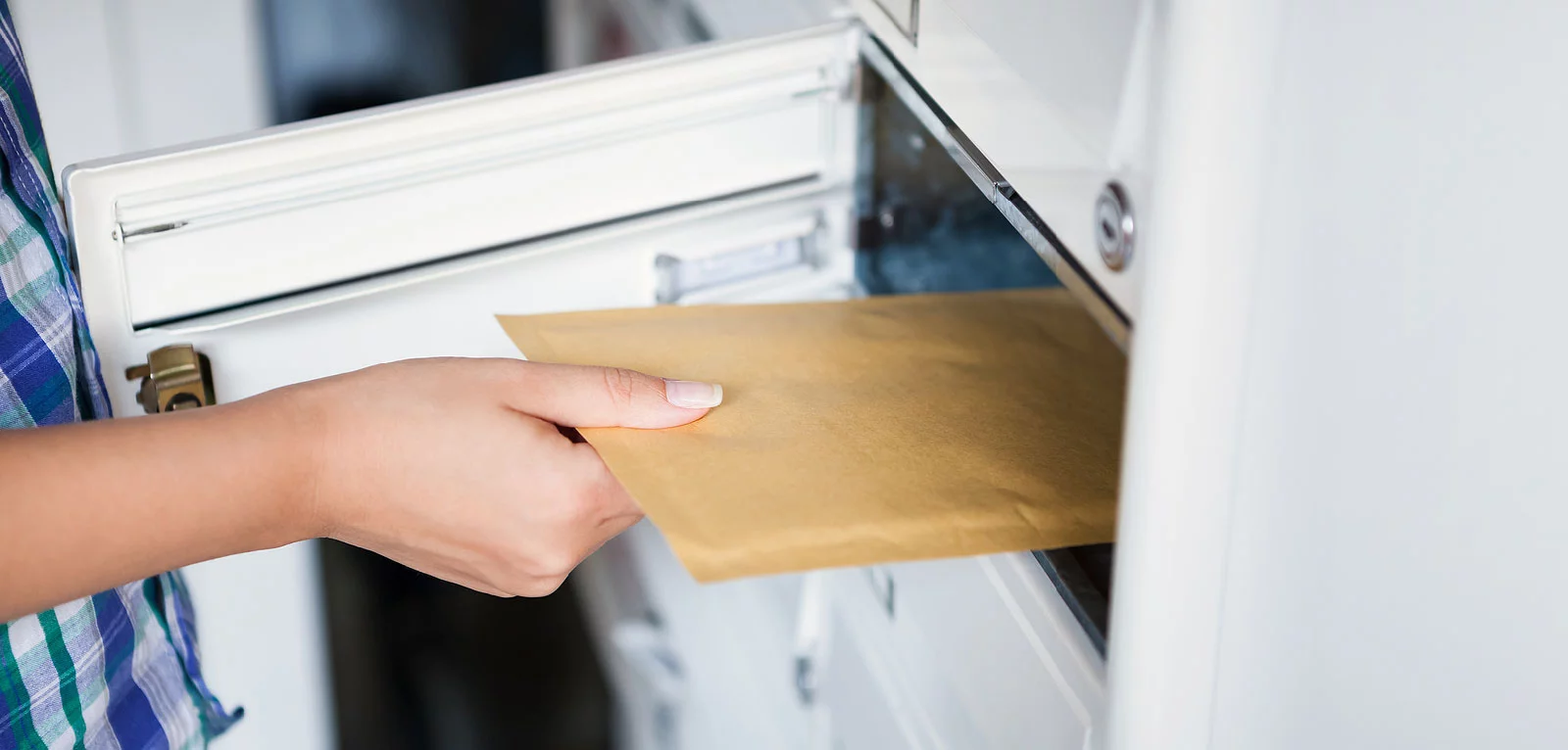 Person putting envelope into private mailbox