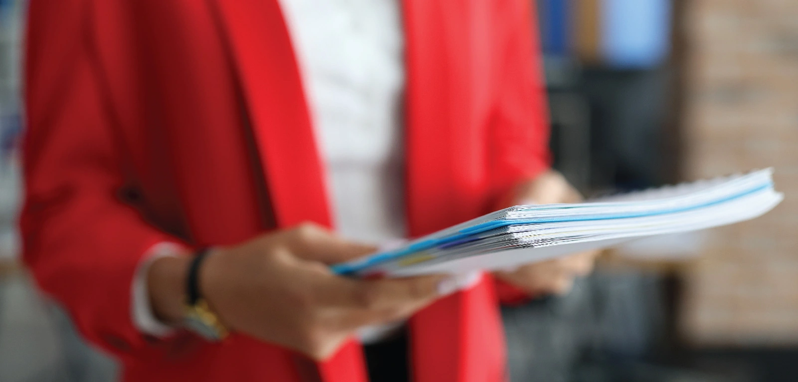 Hands hold a stack of papers